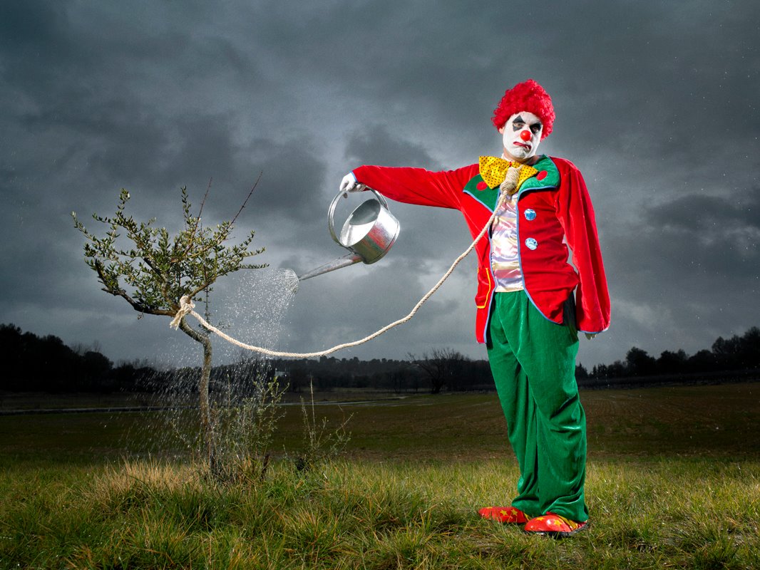 Ведет как клоун. Реми Гайяр. Клоун. Человек клоун. Клоун поливает дерево.